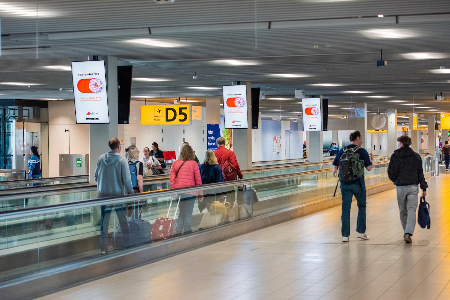 Amsterdam Airport Schiphol, Arrivals corridor · animation lightbox, real DOOH inventory bookable by the hour on Blindspot