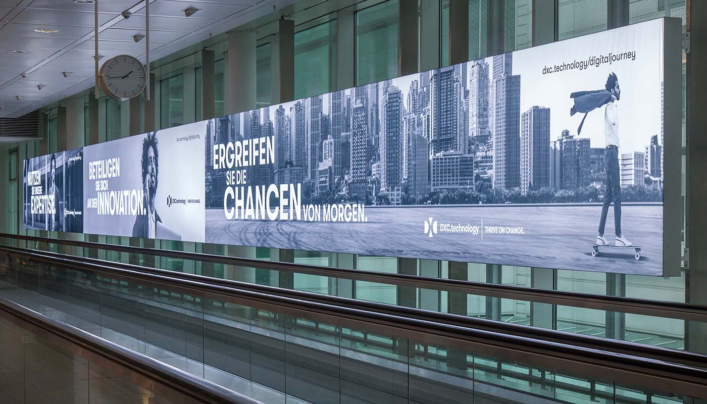Munich Airport, Departures hall · digital pillar network, real DOOH inventory bookable by the hour on Blindspot