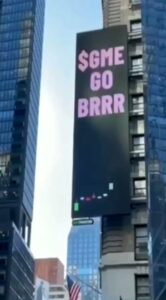 Prominent $GME GO BRRR advertisement illuminating the heart of Times Square on a massive digital billboard.